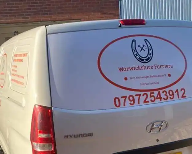 Rear view of a commercial van featuring a large vinyl logo and contact information for a farrier service in Warwickshire, displayed on the back door.