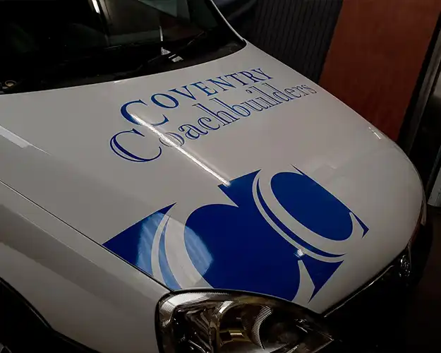 Close-up of a vehicle's bonnet featuring a logo and text vinyl branding for a coventry based coachbuilding company, with a striking blue graphic design.