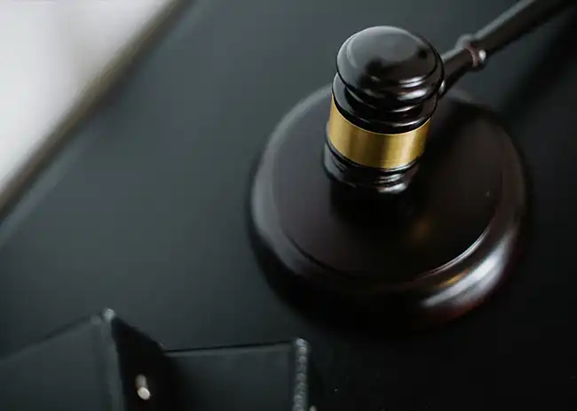 Close-up of a judge's gavel resting on a sound block, symbolising law, justice, or a legal decision.