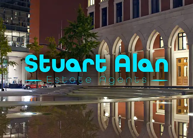 Logo for Stuart Alan Estate Agents overlaid on a night-time photo of a modern birmingham building with arched windows, reflecting in a water feature, featuring bright blue text contrasting with the warm architectural lighting.