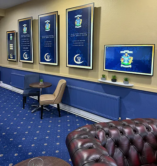 Golf club lounge with multiple digital displays featuring custom graphic designs for winners’ boards and club branding.