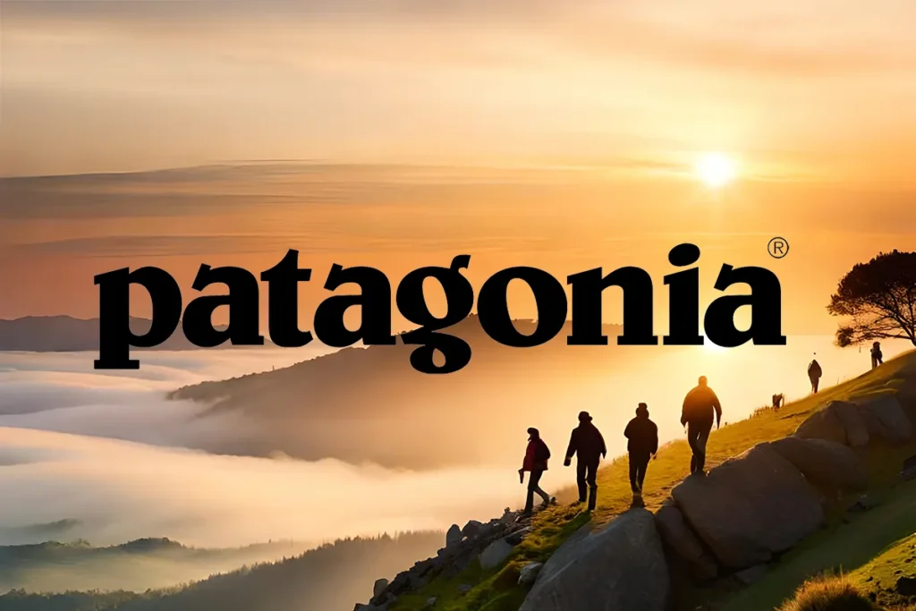 Silhouetted hikers walking along a mountain ridge at sunrise, with the Patagonia logo prominently displayed, symbolising a commitment to outdoor exploration and environmental sustainability.