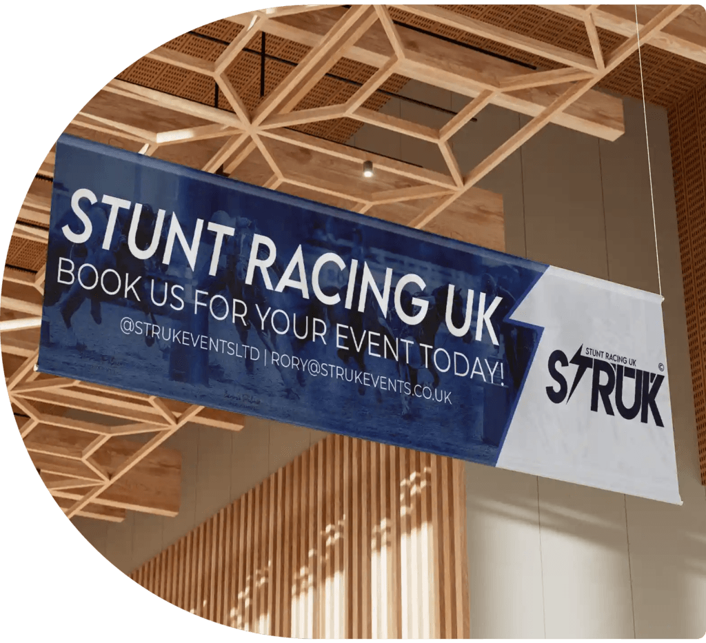 STRUK promotional banner displayed indoors, featuring bold branding and contact details for stunt racing events in the UK