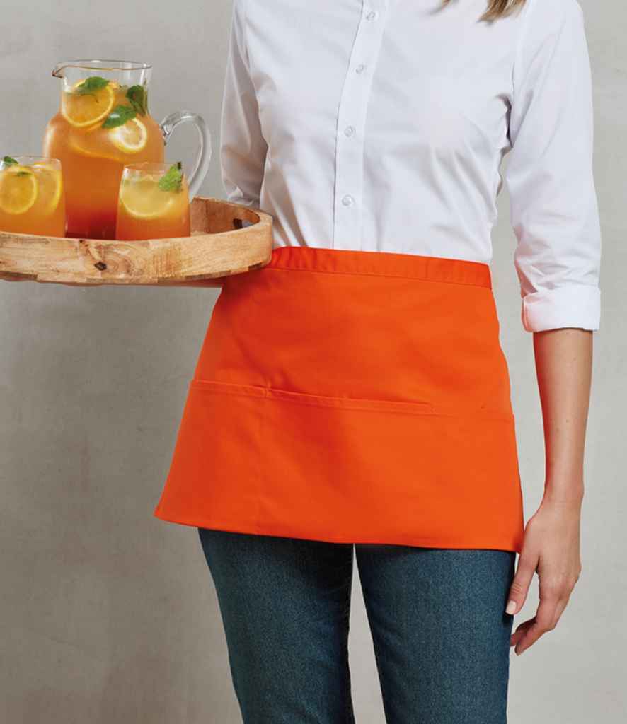 Woman wearing a plain orange waist apron and white shirt, serving drinks ideal for hospitality uniform customisation or branded workwear.